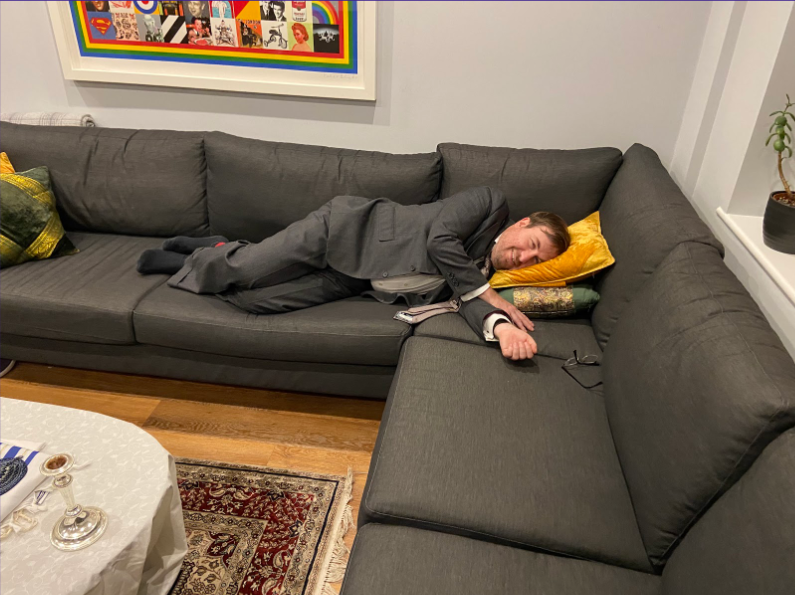 Photo of Josh lying exhausted on the sofa